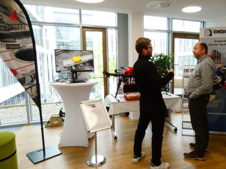 Marvin Bihl erklärt einem interessierten Besucher die automatisierte Übergabe des Transportguts auf dem Tag der offenen Tür